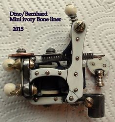 a close up of a sewing machine on a white sheet with the words dino / bernard mini ivory bone liners 2013