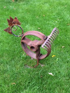 a metal sculpture sitting on top of a lush green field