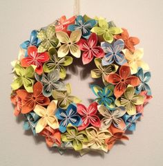 an origami flower wreath hanging on the wall