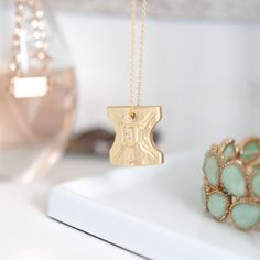 a close up of a necklace on a table with other jewelry items in the background