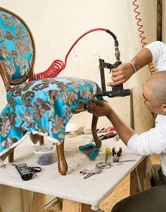 a man working on a chair with tools