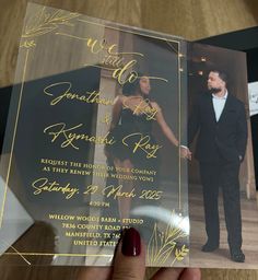 a person holding up a wedding card in their hand