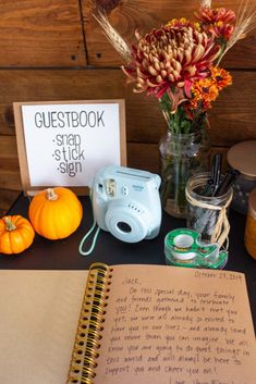 an open notebook sitting on top of a table next to a camera and other items