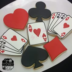 decorated cookies with playing cards and spades on a white platter for valentine's day