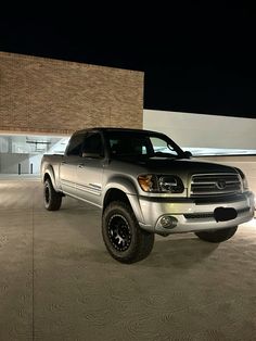 a silver truck parked in front of a building