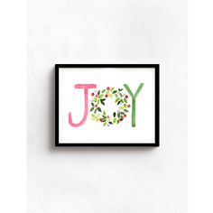 the word joy painted in watercolor on a white wall above a black framed art print