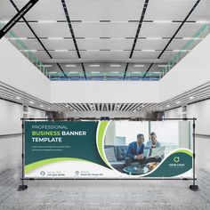 a large banner in an empty room with people working on laptops