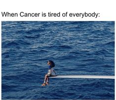 a woman sitting on top of a boat in the middle of the ocean with her legs crossed