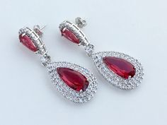 Absolutely stunning!! Ruby red cubic zirconia large teardrop bridal earrings in rhodium plated brass setting. Earrings feature a large teardrop with pear cut red ruby cubic zirconia center surrounded by two rows of clear zirconia crystals. Teardrop dangles from a red ruby cubic zirconia teardrop ear stud. Total length of the earrings is 5.5 cms. To browse my collection click : https://www.etsy.com/your/shops/fantasycrystals Teardrop Bridal Earrings, Red Bridesmaid, Red Bridesmaids, Cubic Zirconia Earrings, Ear Stud, Earrings Red, Zirconia Earrings, Red Ruby, Red Crystals