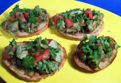 four pieces of bread topped with veggies on a yellow plate