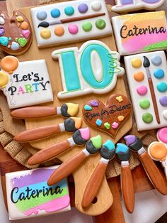 decorated cookies are arranged in the shape of an art class theme on a wooden table