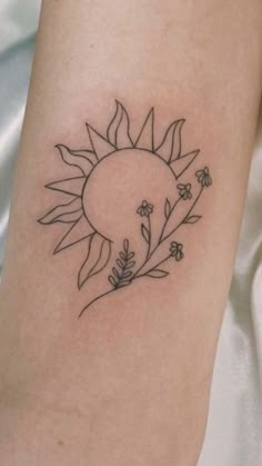 a small sunflower tattoo on the arm with leaves and flowers around it's center