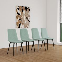 four mint green chairs in front of a painting on the wall and wood flooring