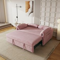 a pink couch sitting on top of a rug in a living room