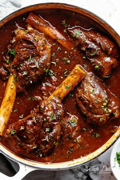 a pot filled with meat and sauce on top of a table