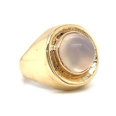 Magical moonstone! This romantic and chic Mid-Century ring features a round moonstone. The cabochon cut moonstone has a soft, icy pink hue and is set on a radiant 14 karat yellow gold band. The bezel features an earthy texture. The perfect accessory for both daytime and nighttime attire. Sleek enchanting in design. Modern Yellow Gold Round Moonstone Ring, Yellow Gold Polished Moonstone Ring, Modern 14k Gold Round Moonstone Ring, Modern Oval Cabochon Moonstone Ring For Formal Occasions, Formal 14k Gold Oval Cabochon Moonstone Ring, Modern Cabochon Moonstone Ring For Formal Occasions, Formal Moonstone Cabochon Ring, Formal Round Moonstone Ring In 14k Gold, 14k Gold Round Moonstone Formal Ring