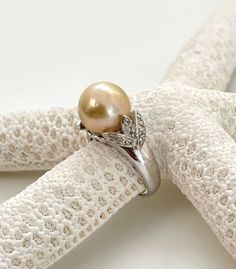 Elegant 11mm Natural Color Golden South Sea Cultured Pearl Ring. Pearl is a very nice size 11mm with High Luster. Ring is 925 Sterling Silver Rhodium Plated with White Topaz accent of 0.20 carat total weight.  Only one in stock! Only available in size 7.      Pearl Type: Golden South Sea, Cultured   Pearl Size: 11mm    Pearl Color: All Natural Gold    Pearl Type: No Treatment  Pearl Origin: Philippines, South Sea        Stone Type: White Topaz  Stone Shape: Round  Treatment: Heated  Country of O Cultured Pearl Ring, Pearl Farm, Country Rings, Ring Pearl, Buy Pearls, Golden South Sea Pearls, Pearl Shop, Natural Gold, Getting Out Of Bed