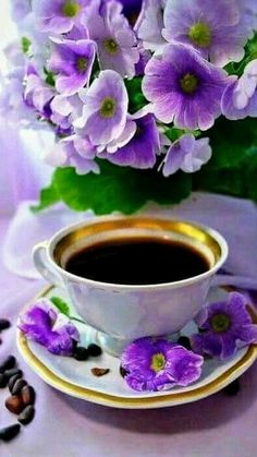 a cup of coffee and some purple flowers