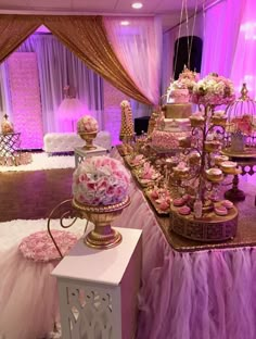 a table topped with lots of cakes and cupcakes