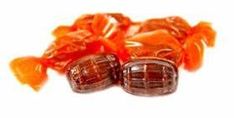 two pieces of chocolate candy sitting on top of each other with orange ribbons around them