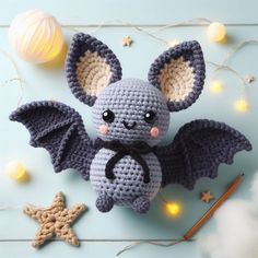 a small crocheted bat sitting on top of a table next to a star