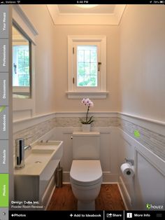 a white toilet sitting under a window next to a sink and mirror in a bathroom