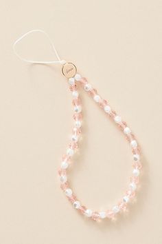 the pink and white beaded necklace is attached to a string with a heart charm