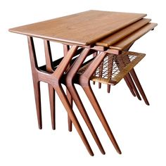 three wooden tables stacked on top of each other with wicker baskets underneath them, against a white background