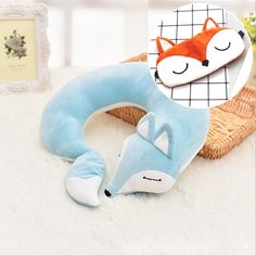 a blue and white pillow with a sleeping fox on it next to a wicker basket