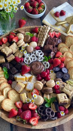 a wooden platter filled with lots of different types of desserts and pastries