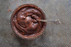 a spoon in a bowl filled with chocolate pudding