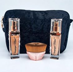 two bottles and a brush sitting next to a black velvet bag on a white surface