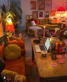 a living room filled with furniture and a laptop computer on top of a wooden table