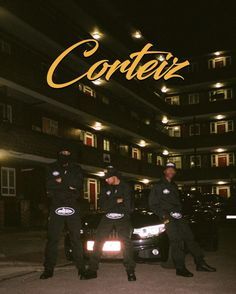 two police officers standing in front of a car at night with the words cortez on it