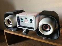 two speakers sitting on top of a wooden shelf