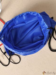 a tennis racquet laying on the ground next to a blue bag