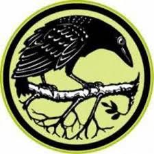 a black and yellow bird sitting on top of a tree branch in a circular logo