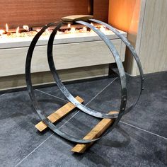 a metal sculpture with candles burning in the fireplace behind it on a tile floor next to a window