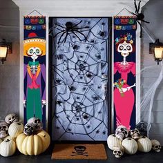 halloween decorations with skeletons and pumpkins in front of a door decorated for the day of the dead