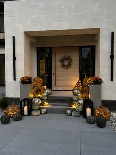 the front entrance to a building decorated with pumpkins and candles