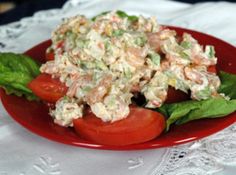 a red plate topped with salad on top of a table