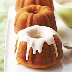 two bundt cakes sitting on top of a white plate next to a green cup