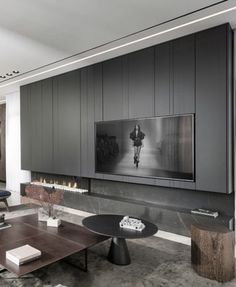 a modern living room with black and white decor on the walls, large television mounted to the wall