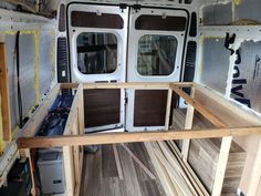 the inside of a van with wooden flooring and windows in place to be installed