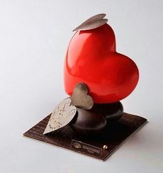 a red heart shaped object sitting on top of a table