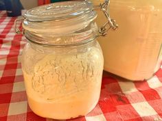 there is a glass jar with liquid in it on the table next to another container