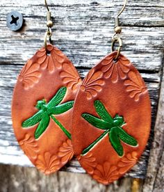 Capture Spring with these beautiful dragonfly earrings.  Deep emerald green adds a pop of color against the warm, earthy backdrop of caramel and tan. Crafted by hand from start to finish, these earrings start out as blank slates of premium veg-tanned leather. From there, I hand-tool, dye, and paint each pair.  All leather pieces are conditioned with beeswax, which keeps leather supple and water resistant (see video). Edges and backs are conditioned and finished, as well. Please remember that tim Green Hand Tooled Jewelry For Gift, Casual Brown Handmade Earrings, Casual Handmade Brown Earrings, Bohemian Hand Tooled Green Jewelry, Green Hand Painted Copper Earrings, Brown Hand Painted Leather Jewelry, Adjustable Hand Painted Brown Earrings, Hand Painted Adjustable Brown Earrings, Vintage Brown Hand Painted Jewelry