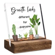 a sign that says growth looks different for everyone with potted plants in front of it