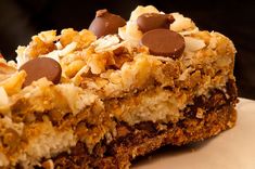 a close up of a piece of cake on a plate with chocolate chips and coconut