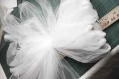 a piece of white tulle sitting on top of a table next to a ruler